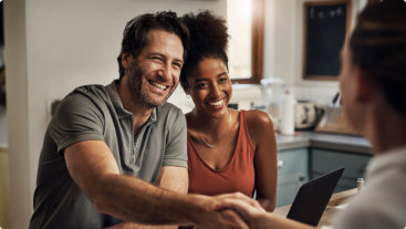 couple smiling at a male financial advisor
